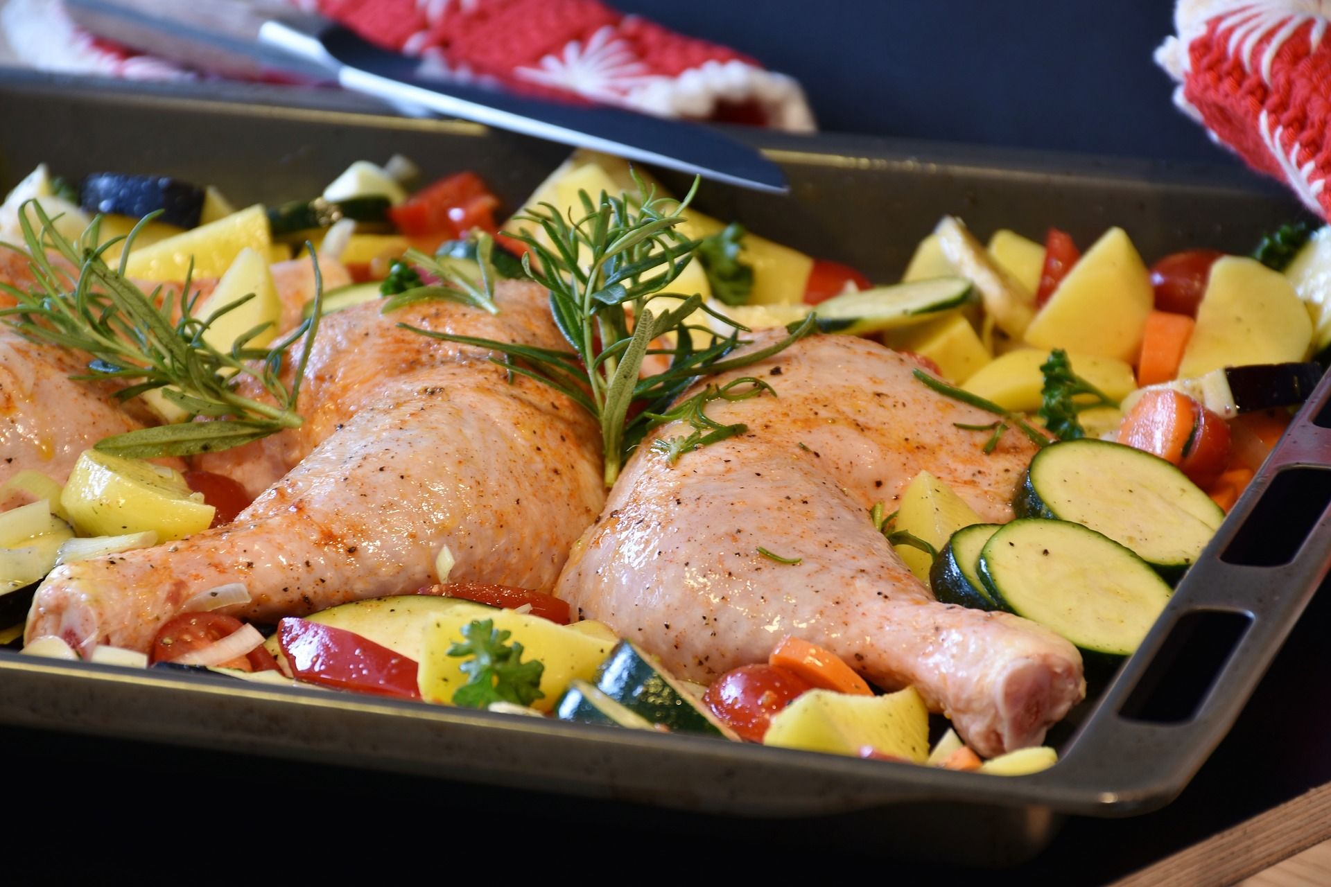 raw chicken in pan of vegetables